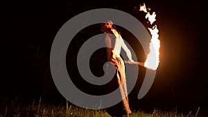 Fire show. Man juggles with two burning torches. Night show. Mastery of the fakir. Low angle