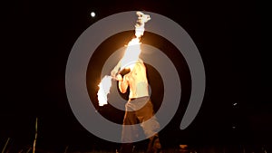 Fire show. Man juggles with two burning torches. Night show. Mastery of the fakir. Low angle