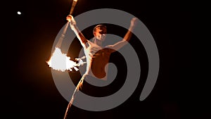 Fire show. Man juggles with two burning torches. Night show. Mastery of the fakir. Low angle