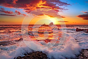 Fire Sky and waves crashing over rocks in Laguna Beach, CA