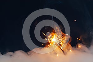 Fire sparkler in dense smoke, abstract Christmas firework background