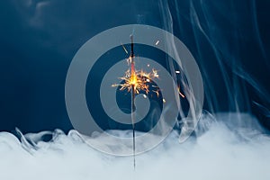 Fire sparkler in dense smoke, abstract Christmas firework background