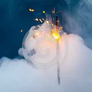 Fire sparkler in dense smoke, abstract Christmas firework background