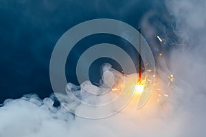 Fire sparkler in dense smoke, abstract Christmas firework background