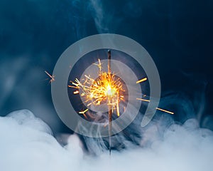 Fire sparkler in dense smoke, abstract Christmas firework background