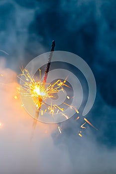 Fire sparkler in dense smoke, abstract Christmas firework background