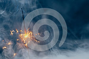 Fire sparkler in dense smoke, abstract Christmas firework background