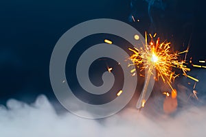 Fire sparkler in dense smoke, abstract Christmas firework background