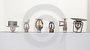 Fire sprinkler heads with fusible links and frangible bulbs