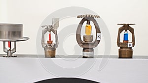 Fire sprinkler heads with fusible links and frangible bulbs