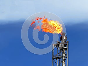 Fire on a stack of flare at oil and gas central processing platform. A gas flare at an oil refinery.