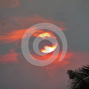 Fire sun behind storm clouds