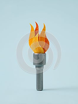 Fire torch symbol made from hex nut tool on blue background for creative simple Olympics sports concept