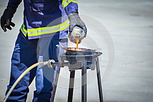 Fire trainer teach pouring oil into pan flames for conflagration