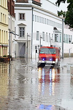 Fire truck drives through the flooded streets of the old town of Lubeck to warn residents during high water when the river Trave