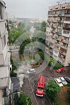 Fire truck near apartment building and extinguish fire in city