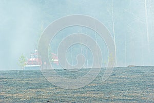 A fire truck stands by the forest