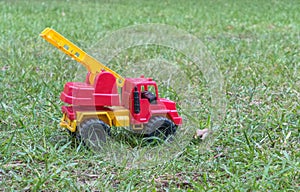 A fire truck toy in the grass.