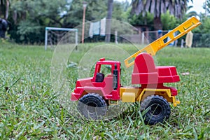 A fire truck toy in the yard of a country house.