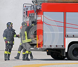 Fire trucks and firefighters with uniforms and protective helmet