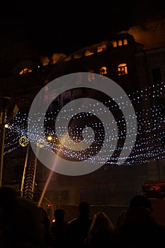 Fire in the windows of the old building at night in winter against the background of garlands. fire extinguishing. Kiev, January