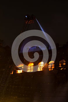 Fire in the windows of the old building at night in winter against the background of garlands. fire extinguishing. Kiev, January