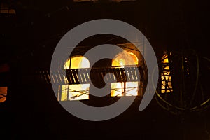 Fire in the windows of the old building at night in winter against the background of garlands. fire extinguishing. Kiev, January