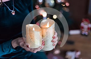 Fire in the woman`s hands. Two burning candles in the woman`s hands. Christmas dreams