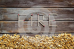 Fire in woodes concept with fire text and kindling frame on wooden background top view