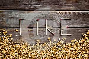 Fire in woodes concept with fire text and kindling frame on wooden background top view