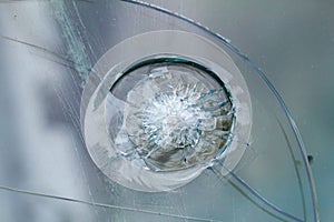 Firearms bullethole on bulletproof glass, cracks background