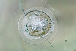 Firearms bullethole on bulletproof glass, cracks background photo