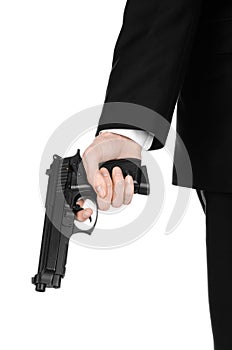 Firearms and security topic: a man in a black suit holding a gun on an isolated white background in studio