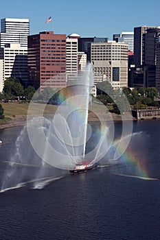 Fireboat in front of marina, city.