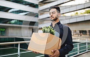 Fired middle eastern manager guy exiting corporate building with box