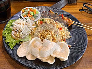 Fired rice or nasi goreng Indonesian chicken fried rice served with pickled cucumber and onion and chili with prawn crackers with