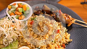 Fired rice or nasi goreng Indonesian chicken fried rice served with pickled cucumber and onion and chili with prawn crackers with