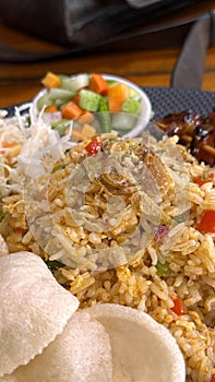 Fired rice or nasi goreng Indonesian chicken fried rice served with pickled cucumber and onion and chili with prawn crackers with