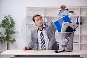 Fired young businessman with recycle bin in time management conc