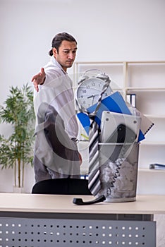 Fired young businessman with recycle bin in time management conc