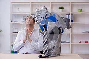 Fired young businessman with recycle bin in time management conc