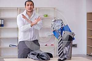 Fired young businessman with recycle bin in time management conc