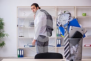 Fired young businessman with recycle bin in time management conc