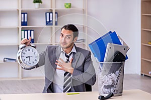 Fired young businessman with recycle bin in time management conc