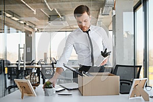 Fired young man packing his stuff in office