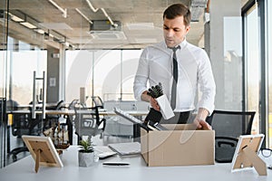 Fired young man packing his stuff in office