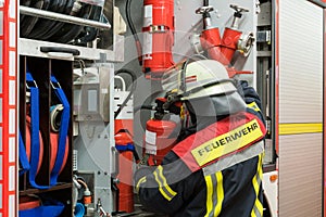 Firefighter in action on the fire truck with a fire extinguisher