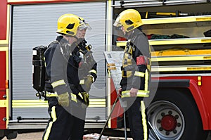 Firefighters in breathing gear are briefed