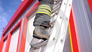 A firefighter climbs the ladder,stairs.. Fire house background. Fireman background.