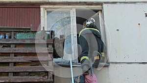 Firefighter climbs up an apartment window to save people. A fire in an apartment building.